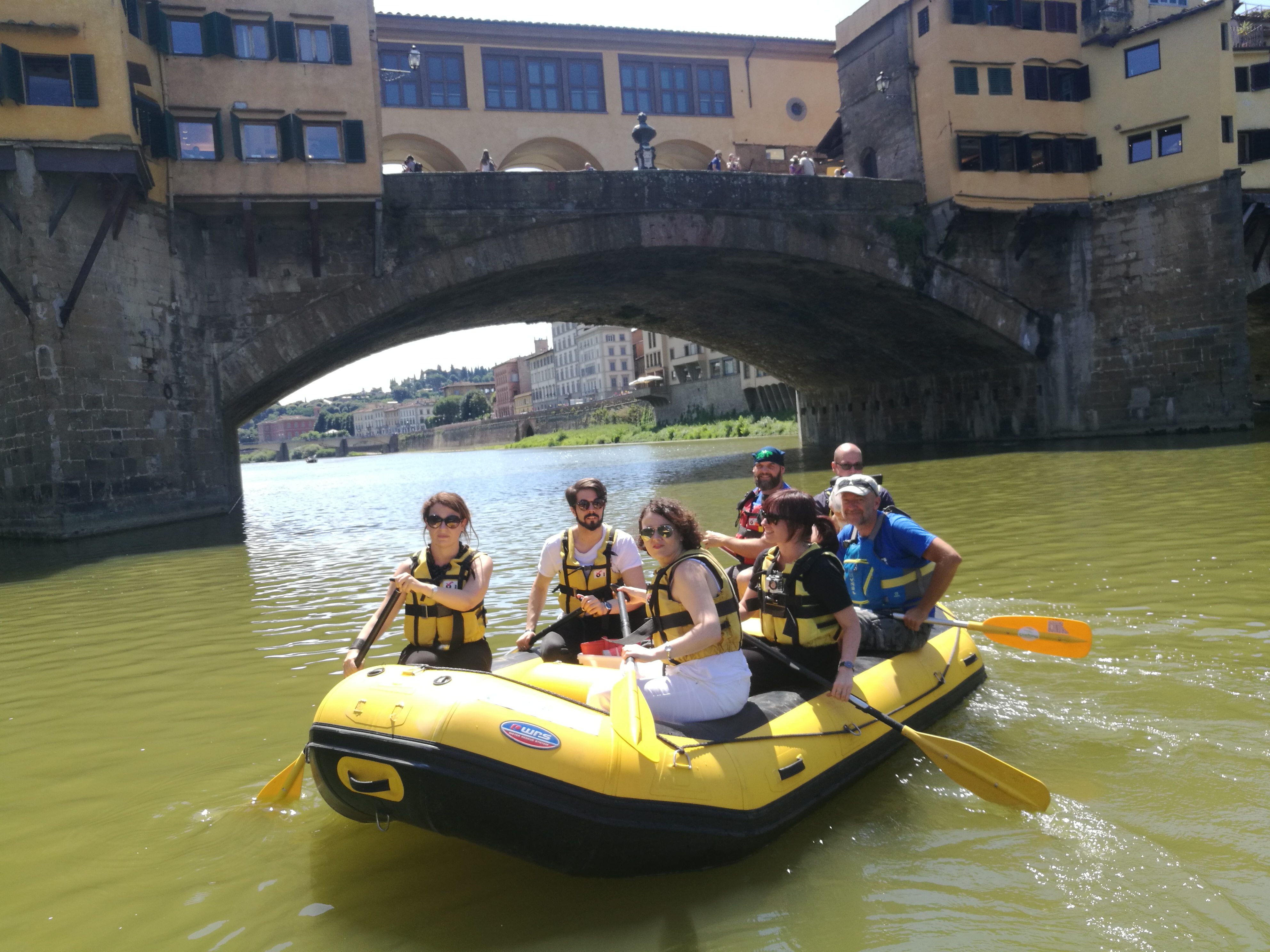I giornalisti arrivano alla conferenza stampa navigando sull'Arno su un raft.