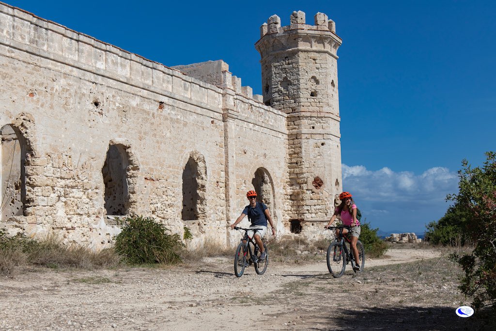 Cicloturisti davanti a ruderi castello di Pianosa