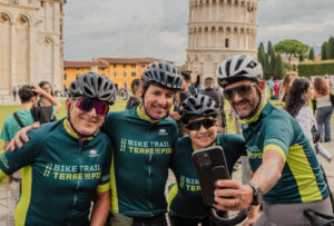 Cicloturisti che di fanno un selfie davanti alla Torre di Pisa