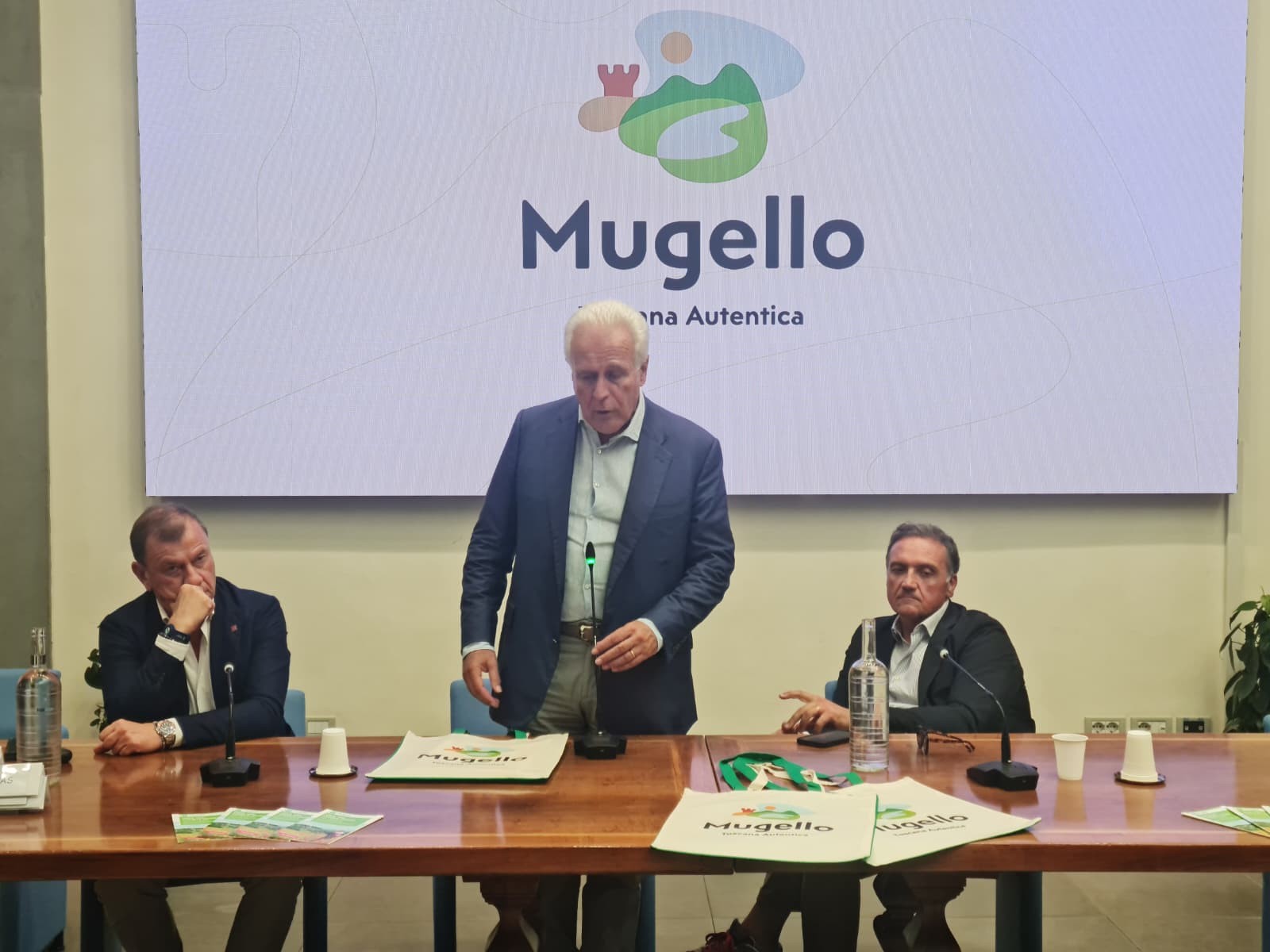 Presentazione Giani in piedi che parla con il nuovo logo dell'ambito Mugello alle spalle